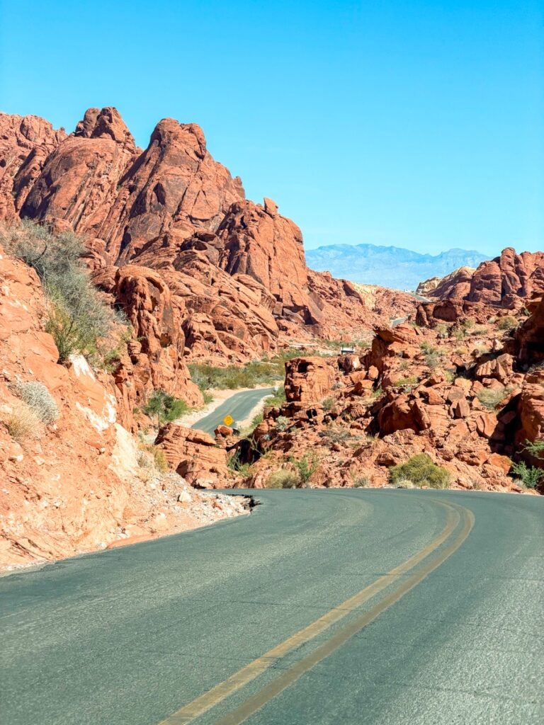 The road curving between red rock formations on the way into the Valley of Fire