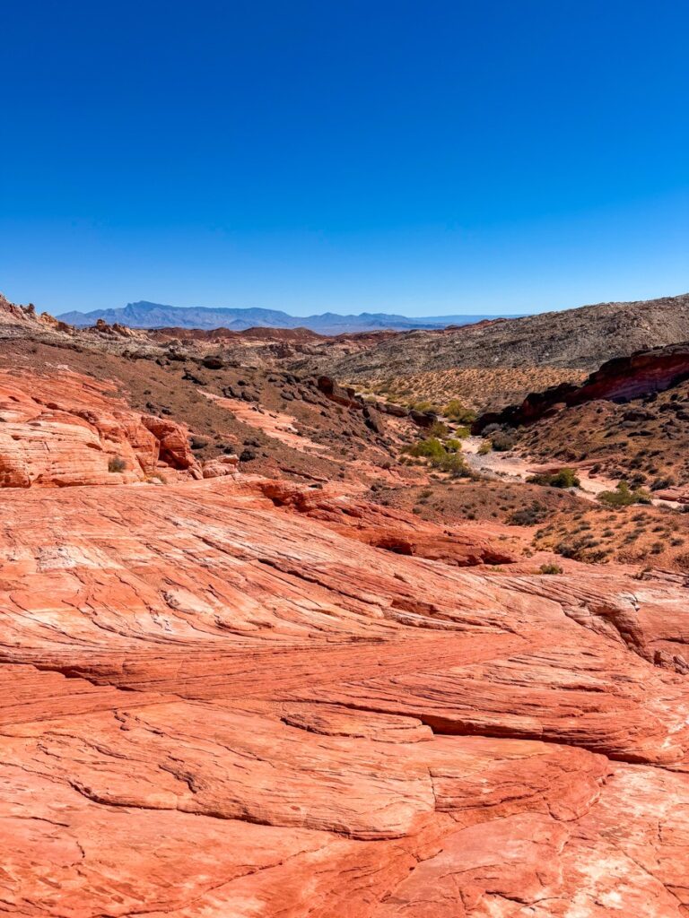 Layered red sandstone slabs and distant mountains in the Valley of Fire State Park
