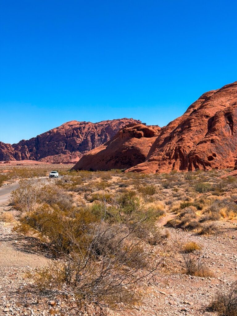 A car on the road through the red rock desert of the Valley of Fire State Park