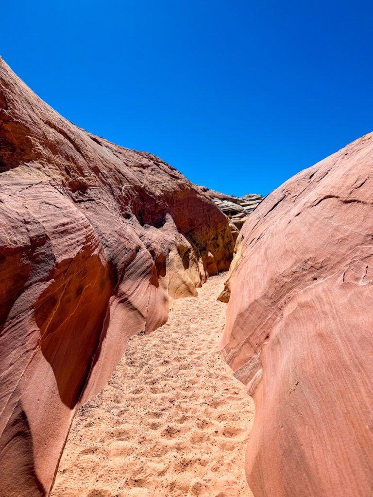 A sandy canyon between pink sandstone walls on the Seven Wonders Loop