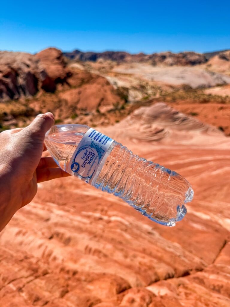 Holding a bottle of water on the hot red rock of the Valley of Fire State Park